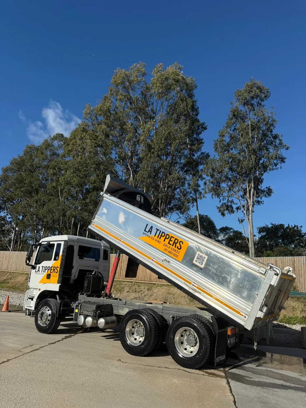LA Tippers tipper truck side-on with tray raised, discharging